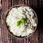 Light and fluffy white rice in a serving dish, garnished with fresh basil.