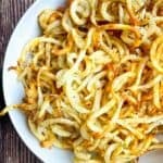 Crispy curly fries in a white serving bowl.