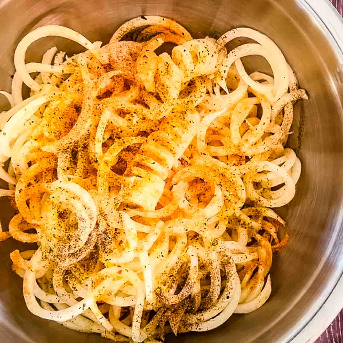 The curly potatoes seasoned in a bowl.