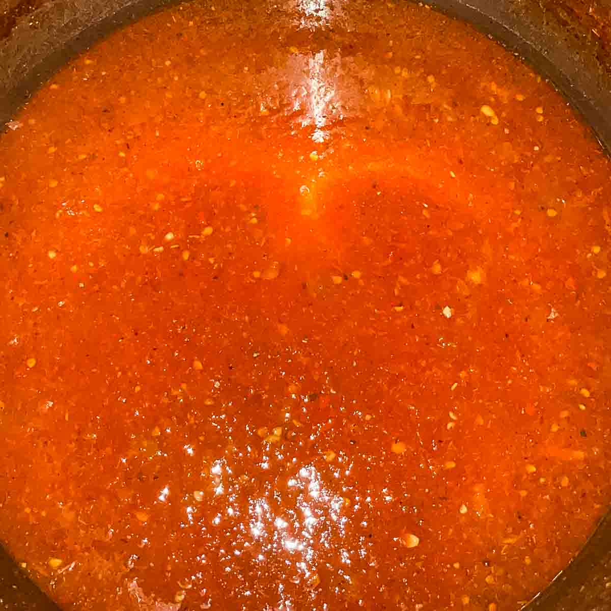 The spaghetti sauce in a large pot after it has cooked down.