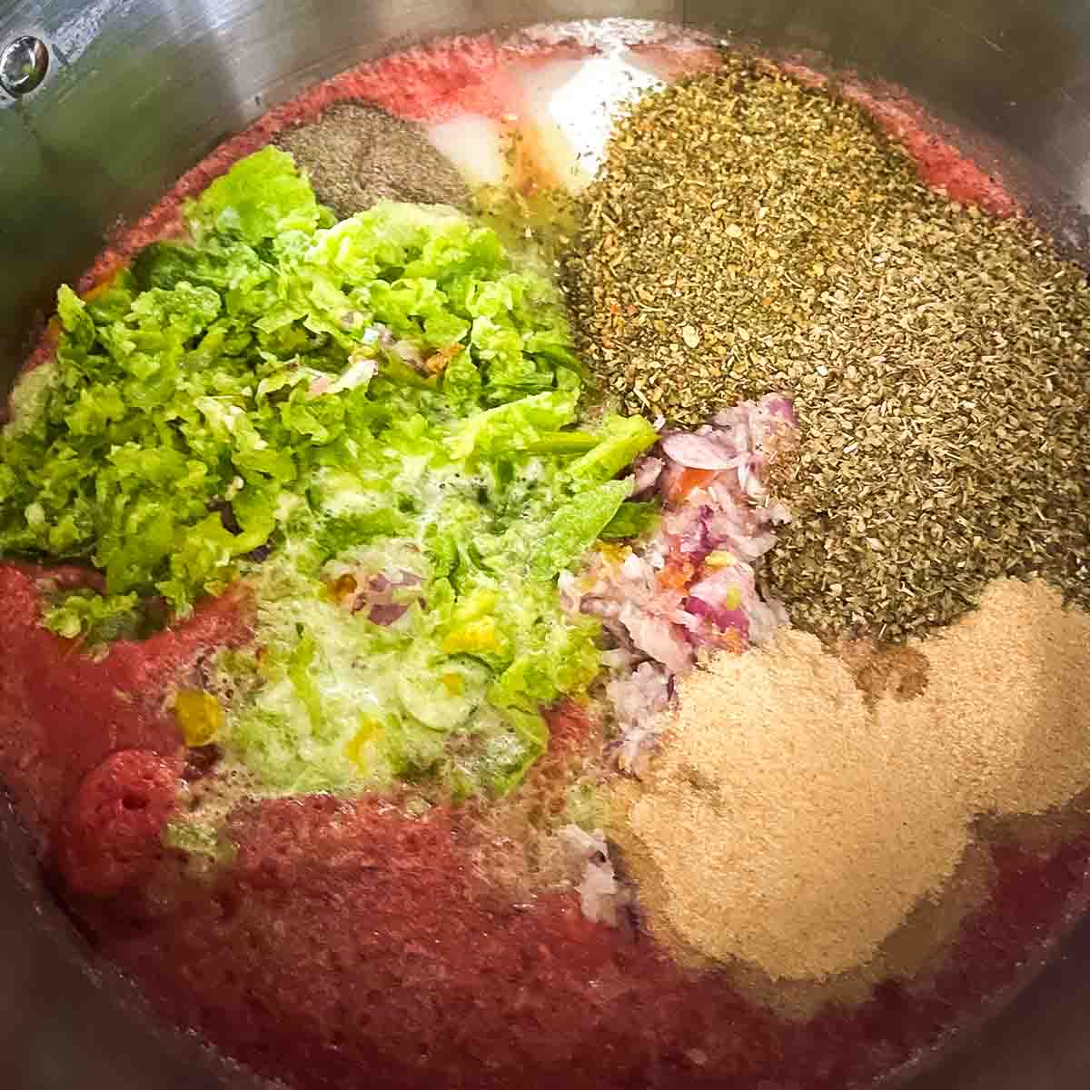 The ingredients for the homemade spaghetti sauce in a large pot.
