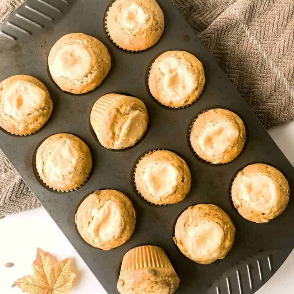 A muffin tin of Starbucks copycat pumpkin cream cheese muffins after they are baked in the oven.