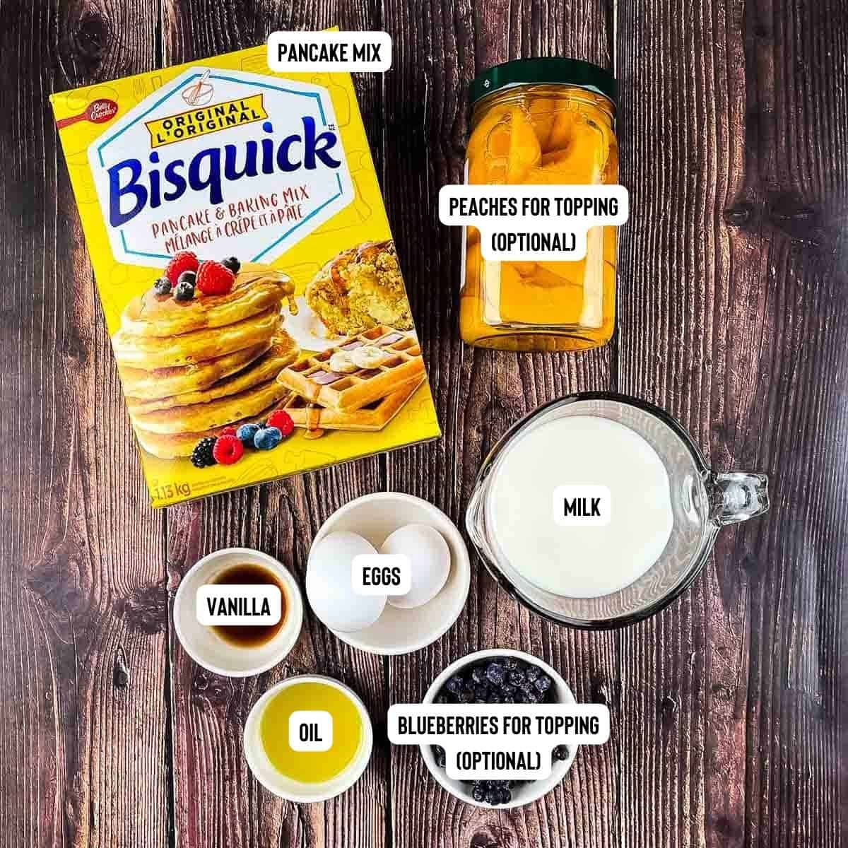 Ingredients to make sheet pan pancakes from mix placed on a wooden table.