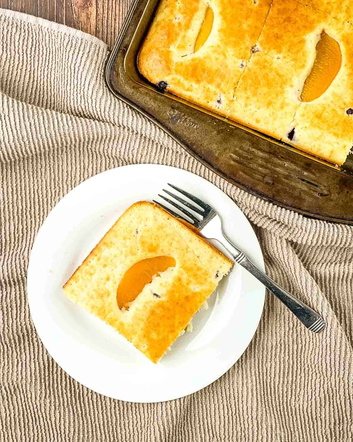 A slice of pancake removed from the sheet pan and placed on a white plate with a fork.