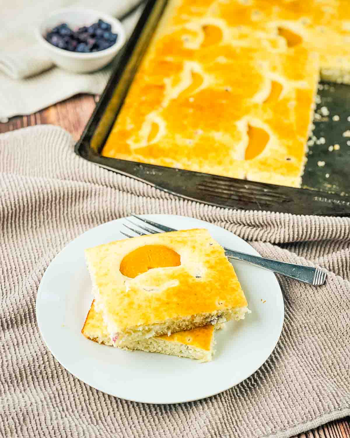 The fluffy pancakes cut in squares and stacked on a white plate.