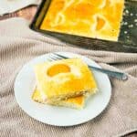 Sheet pan pancakes cut into squares and placed on a white plate.