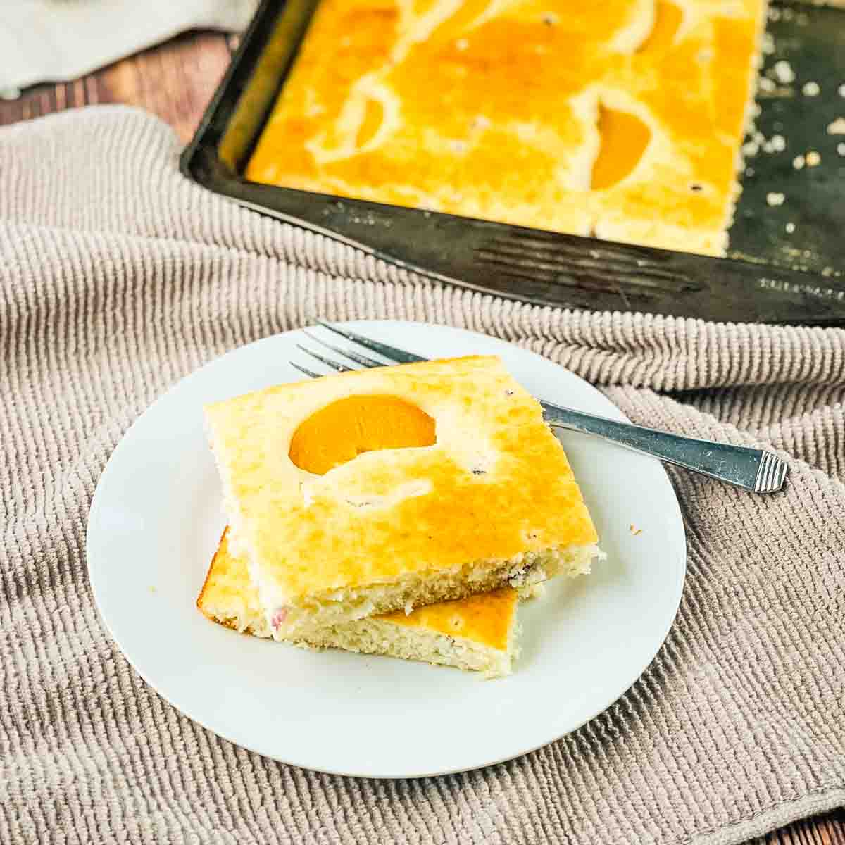 Sheet pan pancakes cut into squares and placed on a white plate.