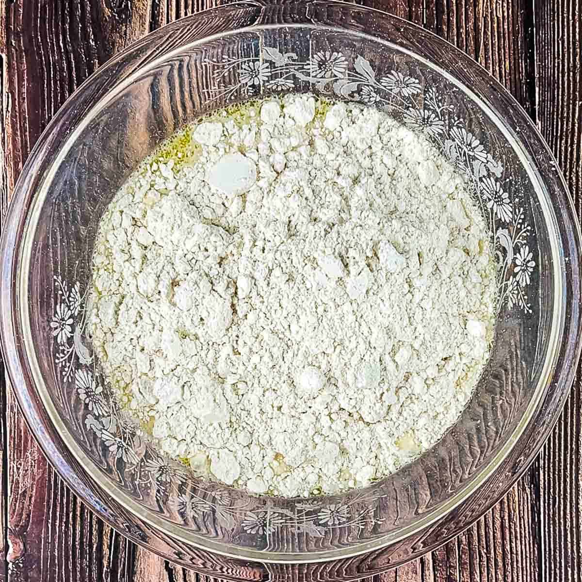 The pancake mix added to the bowl of liquid ingredients.