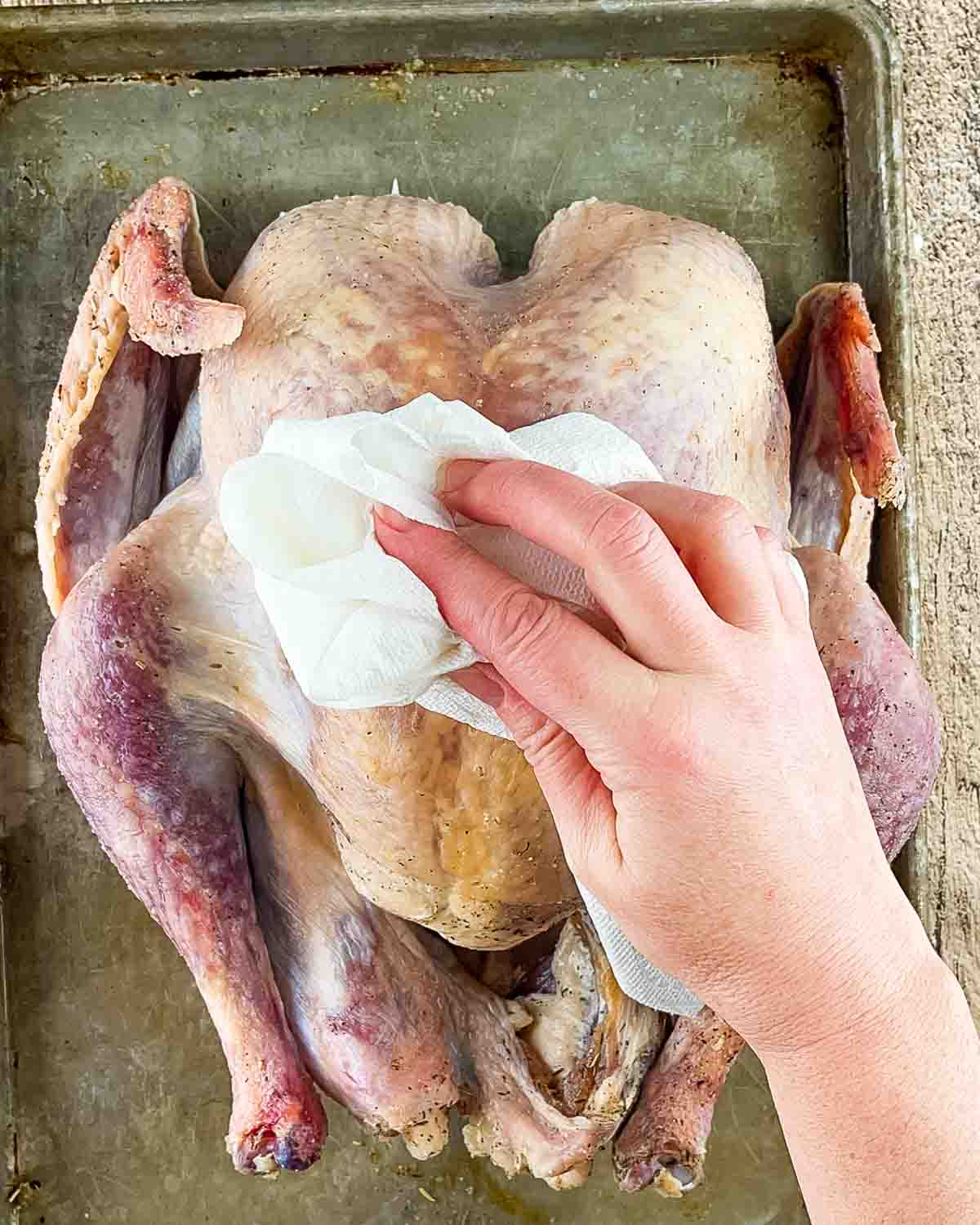 Drying the brined turkey with paper towel.