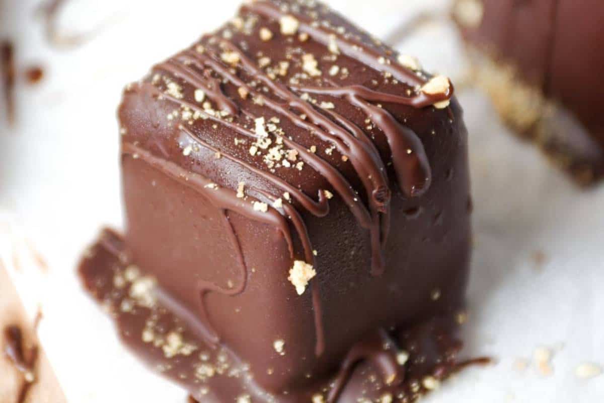 Chocolate Covered Cheesecake Bites displayed elegantly on a serving tray, each piece coated in a shiny chocolate shell.