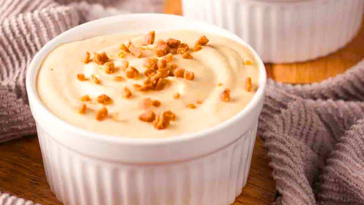 Dulce de Leche Mousse in a glass, topped with a dollop of whipped cream.