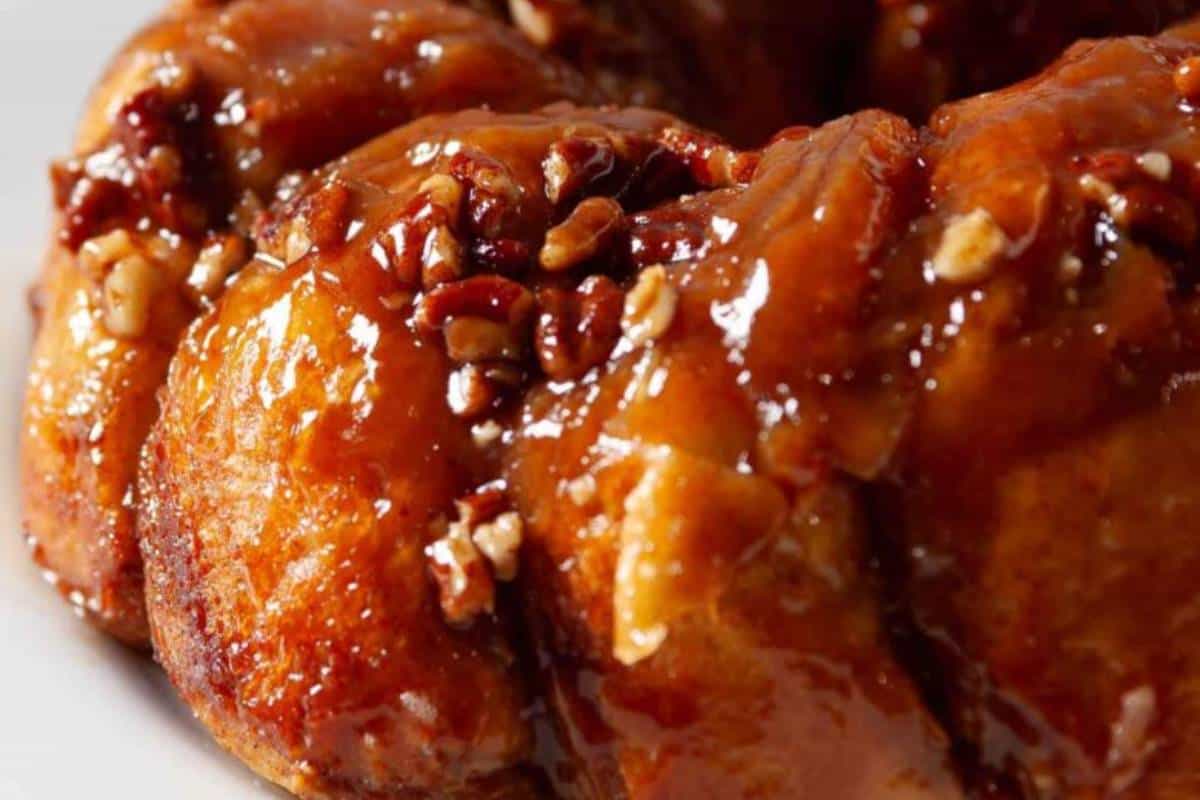 A plate of freshly baked Easy Pull-Apart Sticky Buns, covered in a glossy caramel glaze and sprinkled with cinnamon sugar, served warm and ready to be enjoyed.