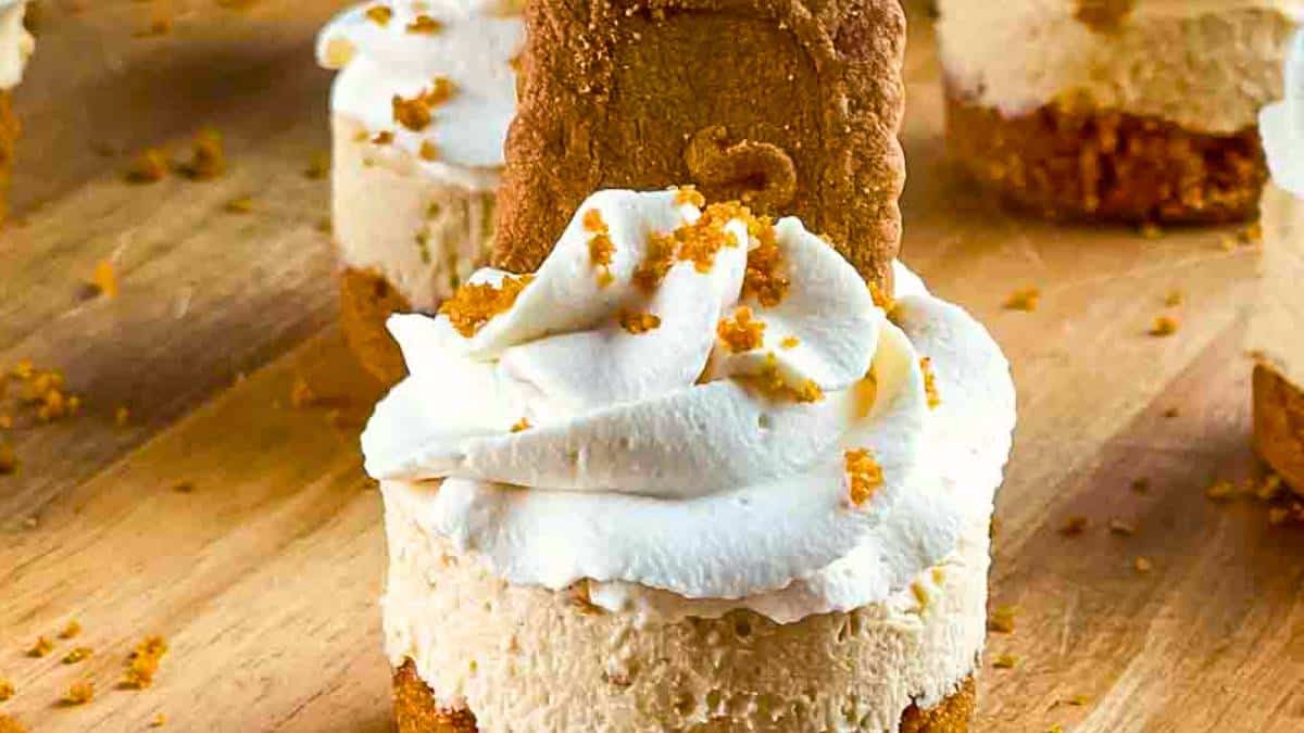 Mini Biscoff Cheesecakes with a cookie crust and creamy filling, topped with whipped cream.