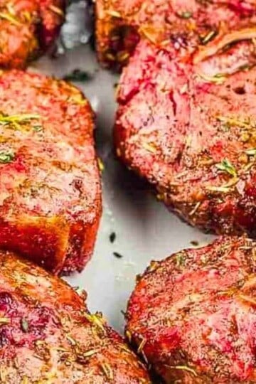 Smoky lamb chops with herbs on a serving platter.