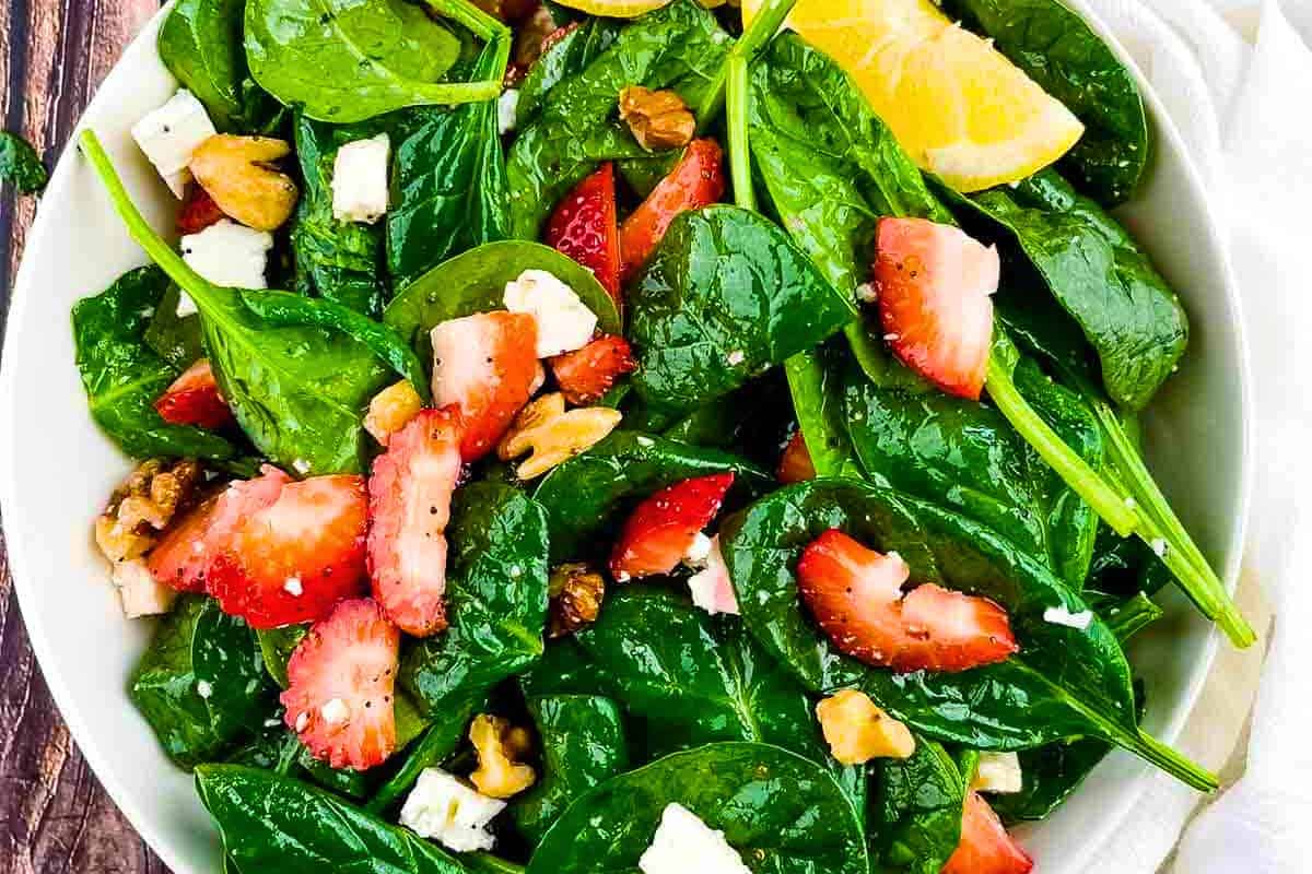A bowl of Strawberry Spinach Salad with Lemon Poppy Seed Dressing featuring juicy strawberries and tender spinach, perfect for a light lunch or refreshing side dish.