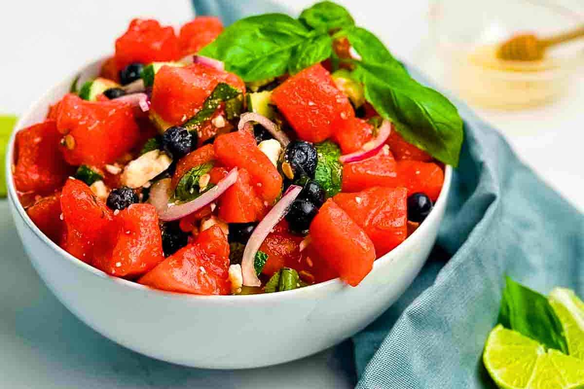 A bowl of Watermelon Basil Salad with Feta and Honey Glaze, featuring juicy watermelon, tangy feta, and sweet blueberries.