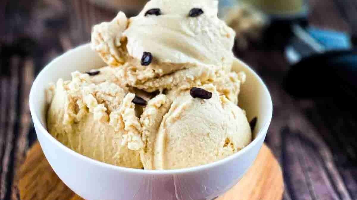 Three scoops of coffee ice cream topped with a sprinkle of coffee beans.