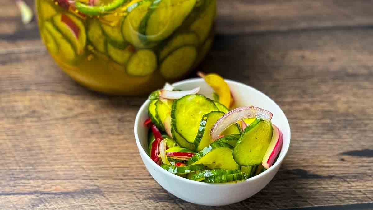 A serving bowl filled with bread and butter refrigerator pickles.