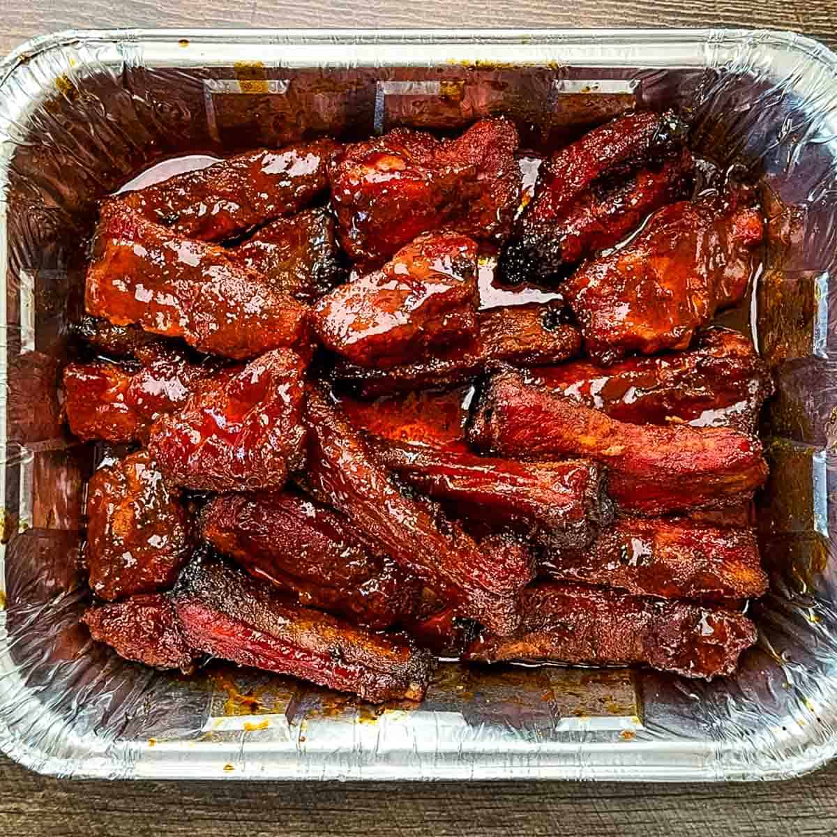 Smoked party ribs with a caramelized glaze, showcasing its tender, juicy texture and rich color.