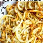 A serving plate filled with crispy, golden brown homemade curly fries made in the air fryer.