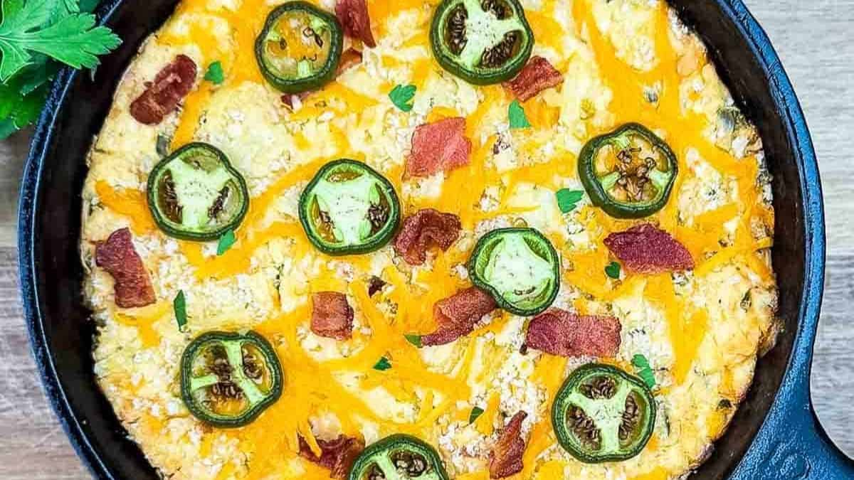 A bubbling dish of creamy, smoky dip topped with crispy bacon and jalapeños.