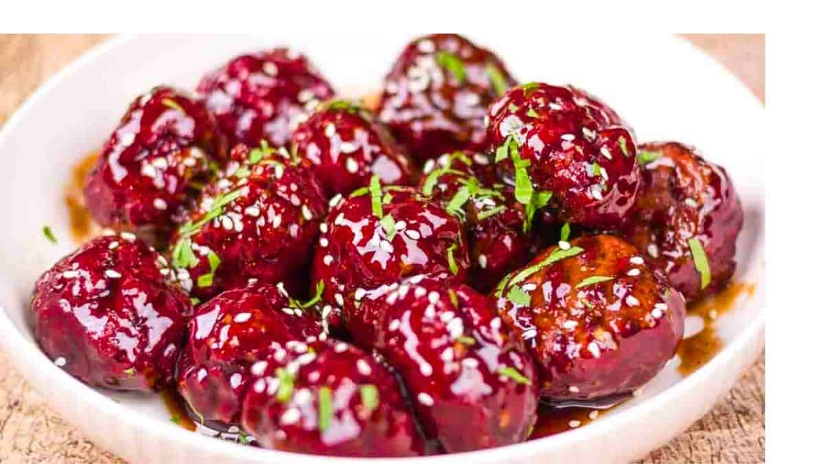 Perfectly smoked venison meatballs with a beautiful smoke ring, garnished with sesame seeds and green onions.