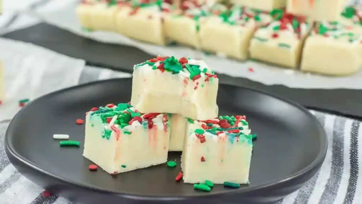 Creamy white fudge squares topped with colorful holiday sprinkles arranged on a serving plate.