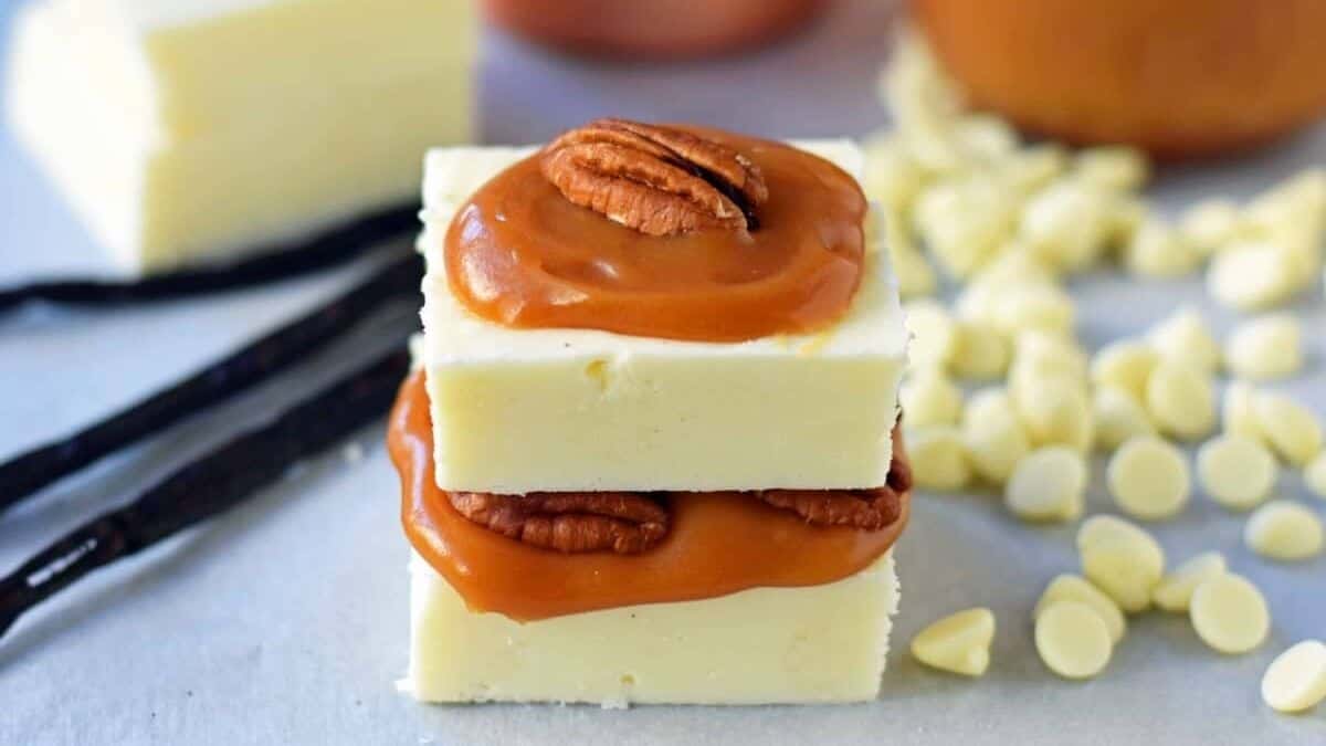 Pure white squares of fudge with caramel and pecan on top.