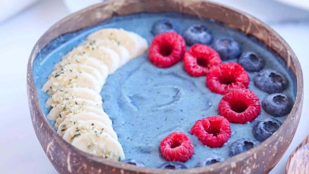 A stunning blue smoothie bowl decorated with fresh fruit.