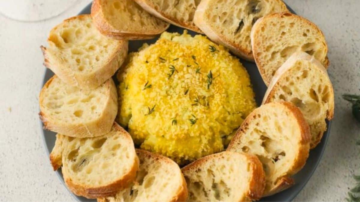 Crispy Boursin cheese on a serving tray with bread for serving.