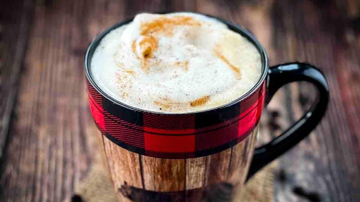 Barista-worthy latte in a dark mug, garnished with cinnamon.