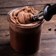 An ice cream scoop scooping up the Fairlife chocolate milk ice cream from a Ninja Creami pint jar.