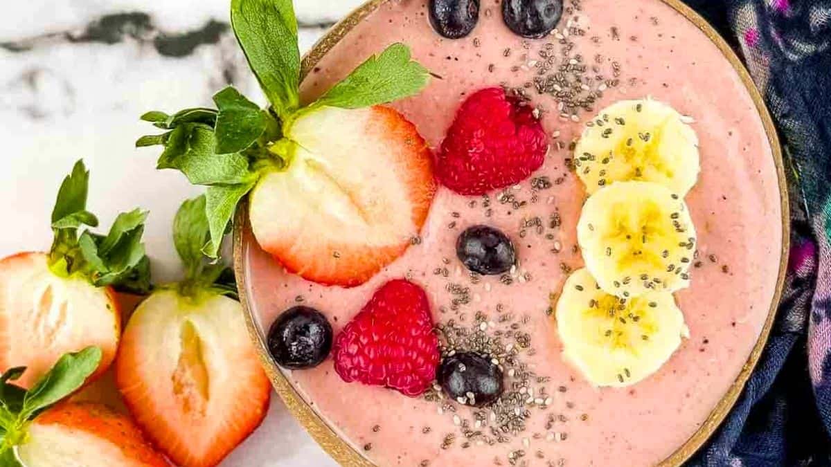 A creamy smoothie bowl with a hearty oat and seed topping.