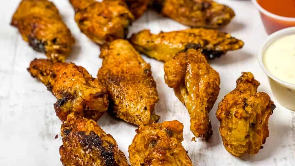 Crispy air fried wings with ranch dressing and buffalo sauce on the side.