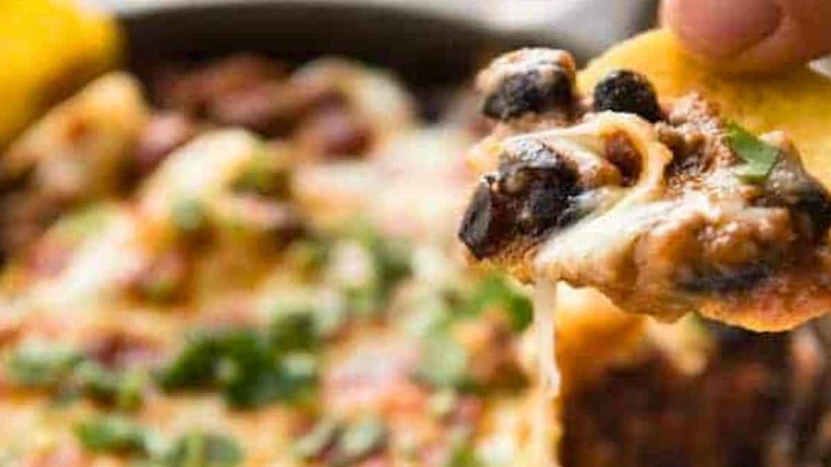 Hot enchilada dip being scooped up with a chip.