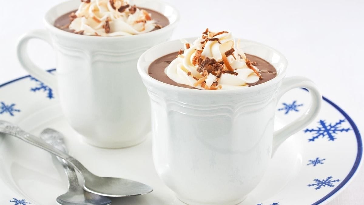 Creamy dairy-free hot chocolate made with coconut milk, topped with coconut whipped cream and toasted coconut.