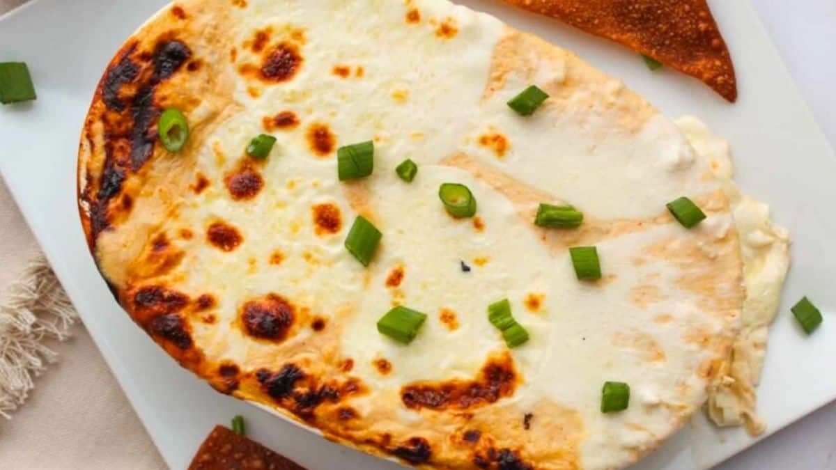 Crab rangoon dip in a baking dish, garnished with green onion.