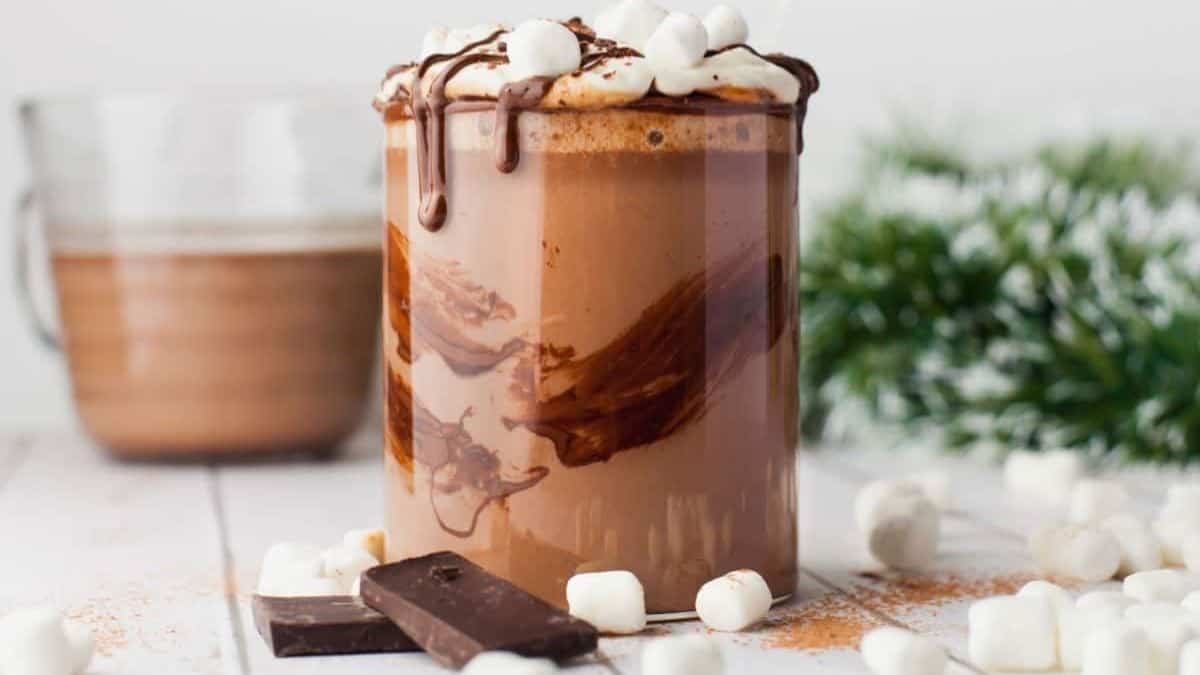Velvety hot chocolate topped with swirls of whipped cream and mini marshmallows floating on top.