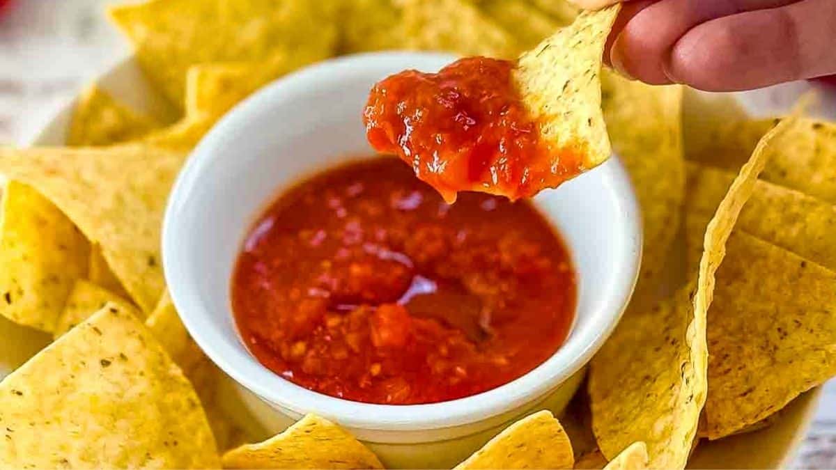 A tortilla chip scooping up fresh homemade salsa.