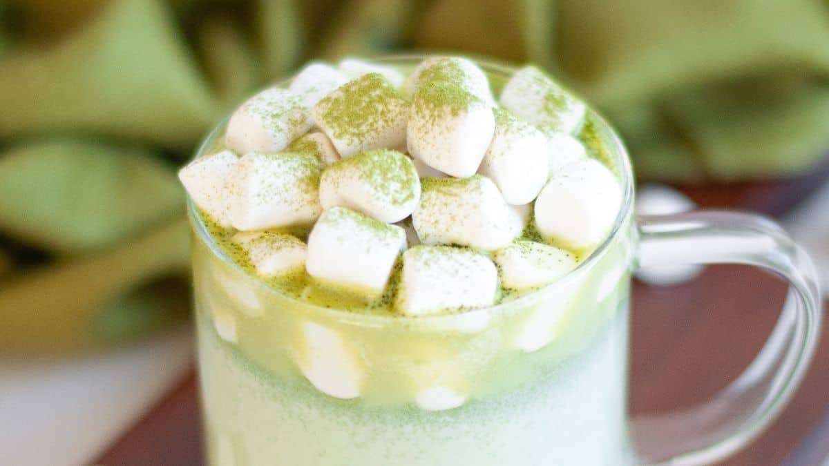 Green matcha white hot chocolate with a dusting of matcha powder on mini marshmallows.