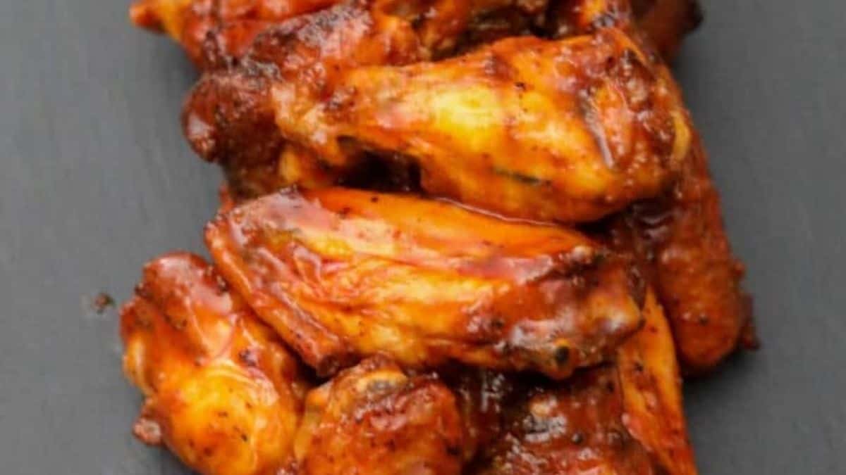 Red-orange wings dusted with Old Bay seasoning served on a platter.