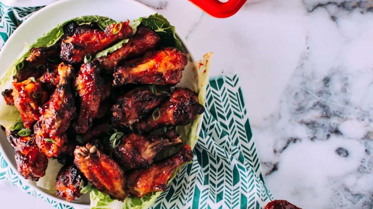 Bright red Korean wings in a serving bowl.