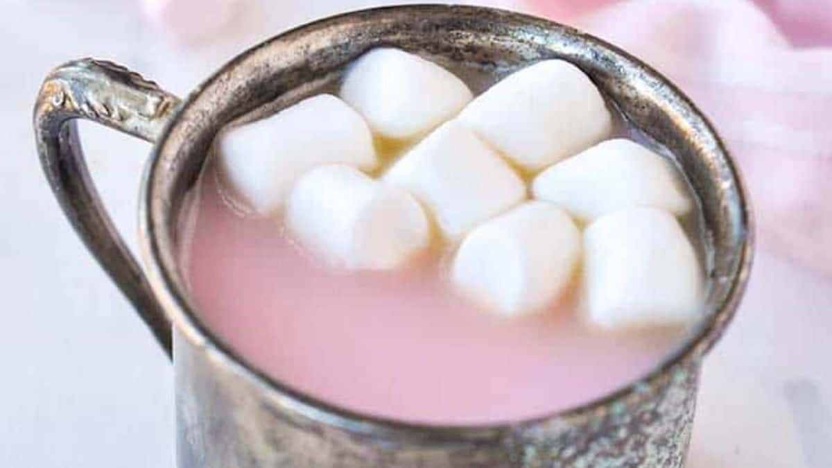 Pink-tinted hot chocolate topped with mini marshmallows.