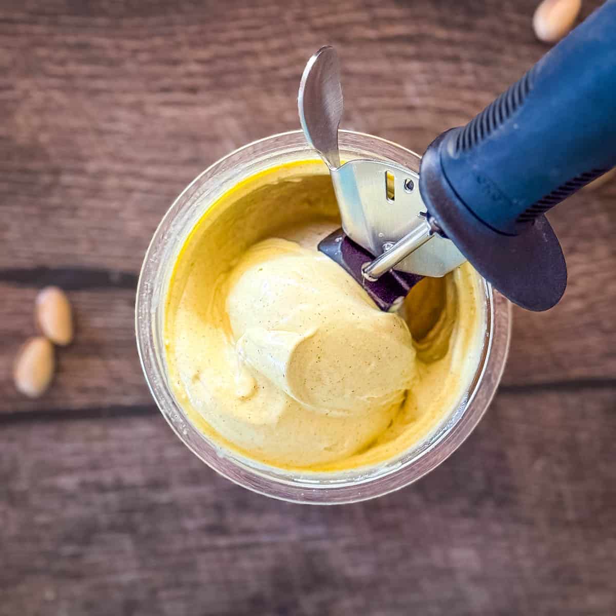 A person is scooping out creamy homemade pistachio ice cream.