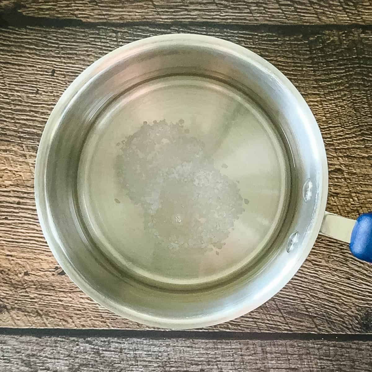 Small pot with water, vinegar, and pickling salt ready to make brine for refrigerator dill pickles.