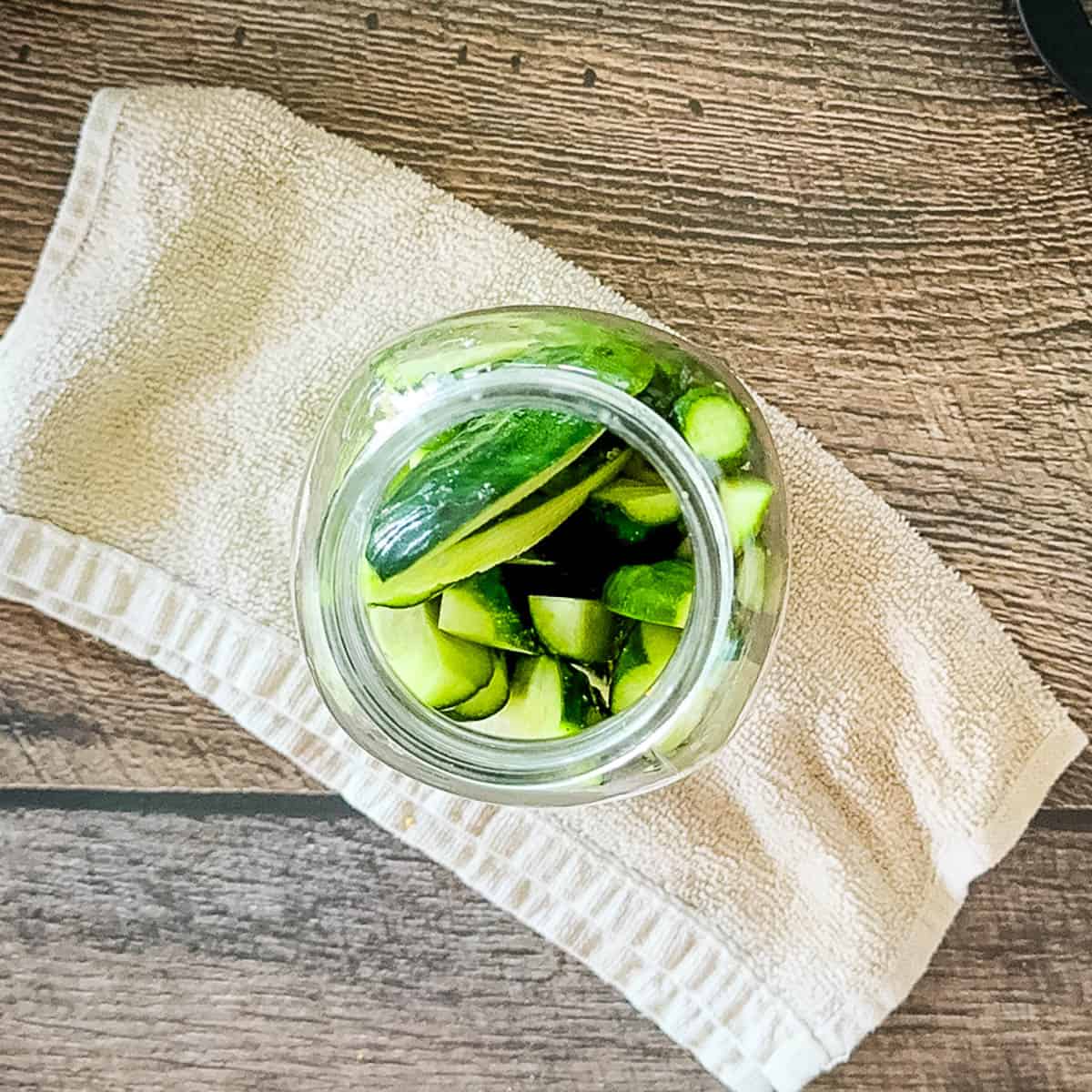Glass jar filled with fresh cucumbers.