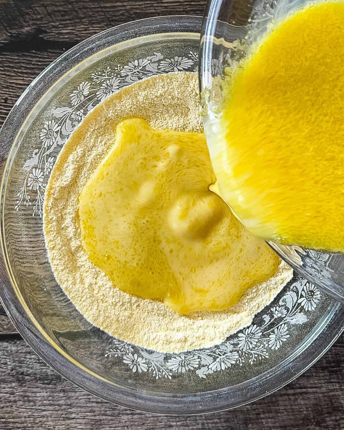 Adding wet to dry ingredients for cornbread batter.