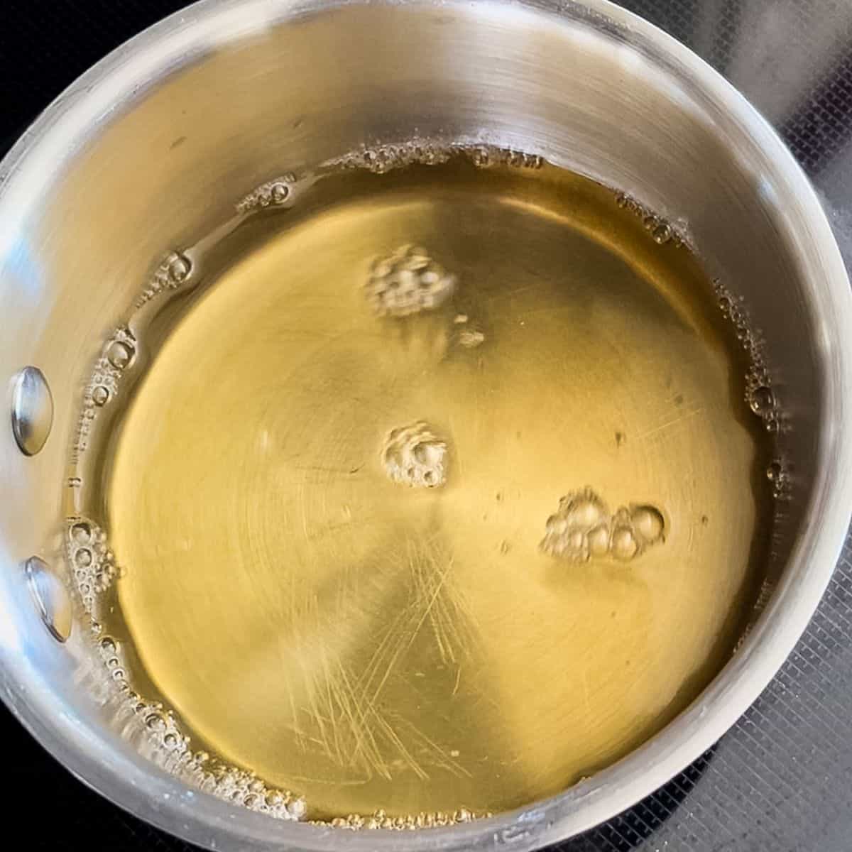 The vanilla simple syrup cooling in a saucepan.