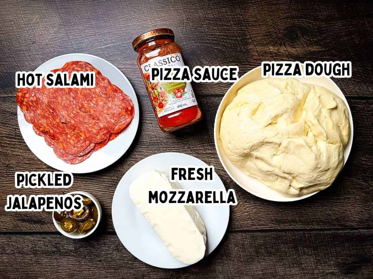 Labeled ingredients for Diavola pizza placed on a wooden table.