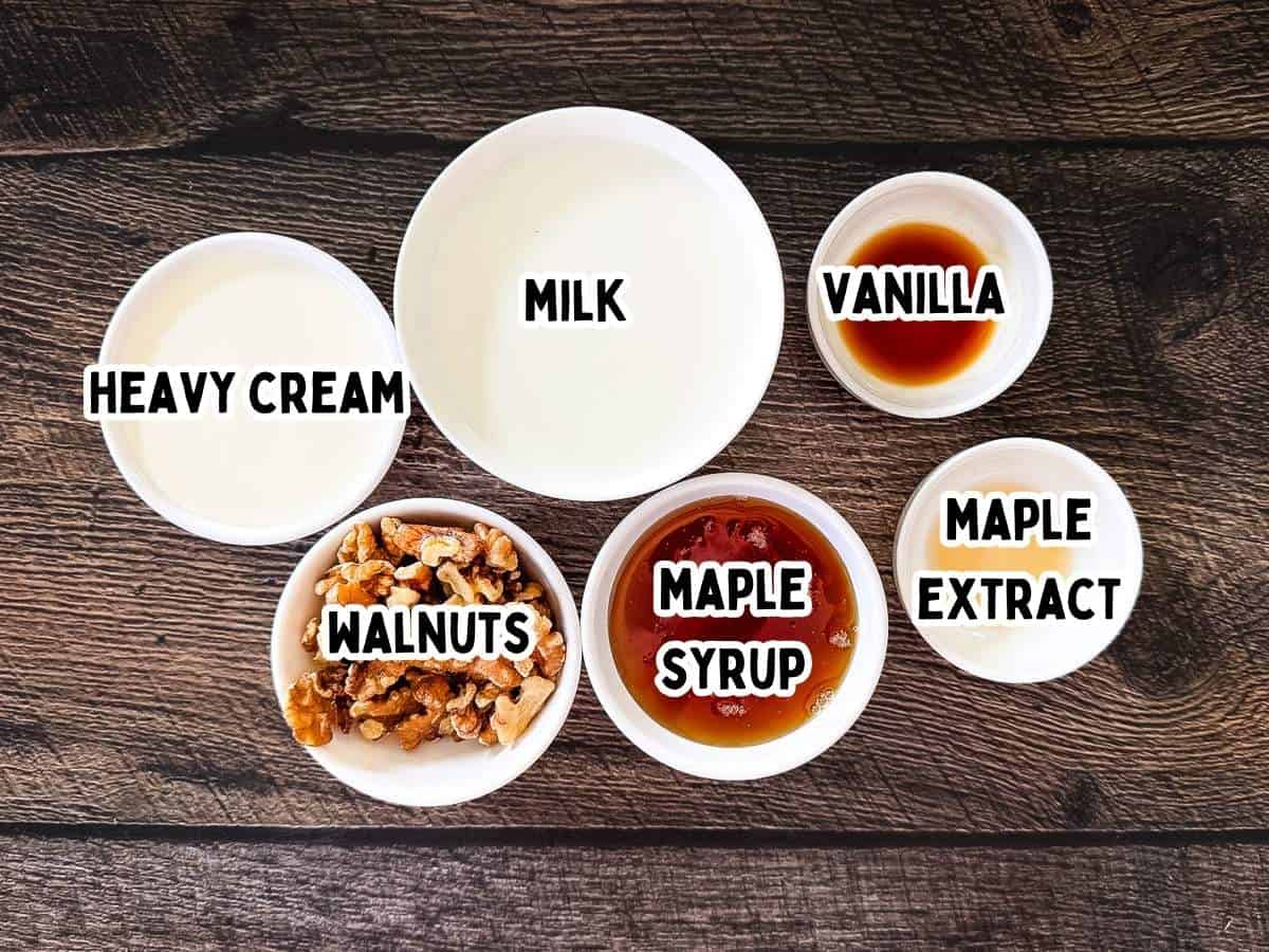 Labeled ingredients shot of Fairlife milk, heavy cream, maple syrup, vanilla, maple extract, and walnuts on a wooden table.